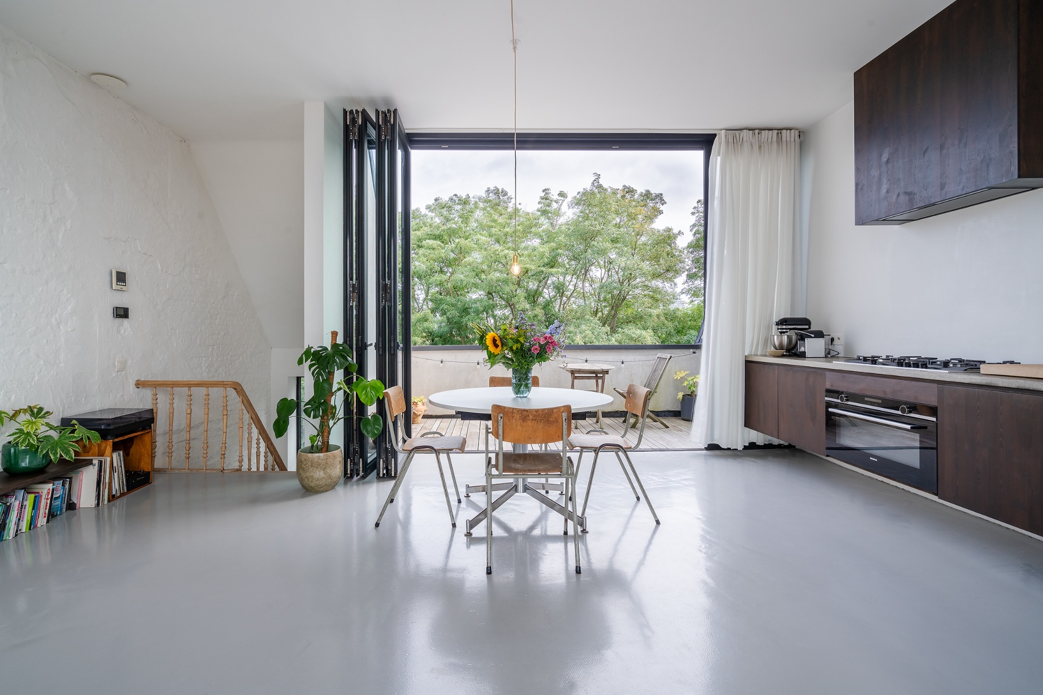 Leefruimte met open keuken, terras en groen uitzicht