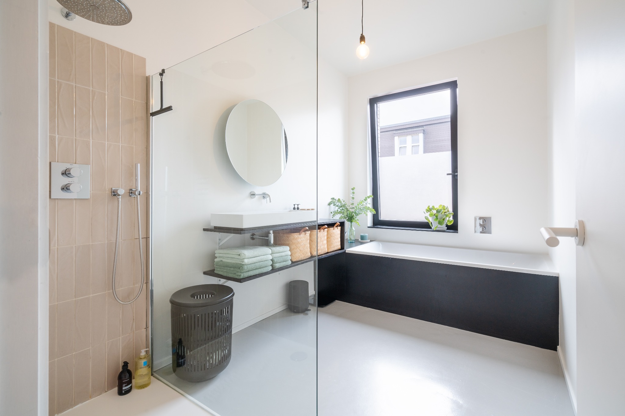 Overzicht van de badkamer met bad en inloopdouche